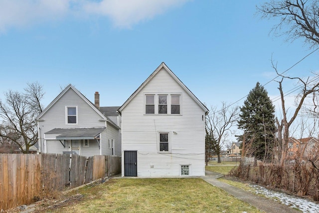 rear view of house featuring a yard