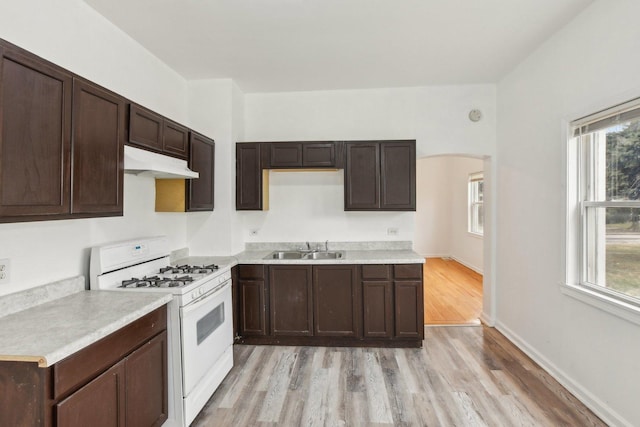 kitchen with gas range gas stove, sink, a healthy amount of sunlight, and light hardwood / wood-style floors