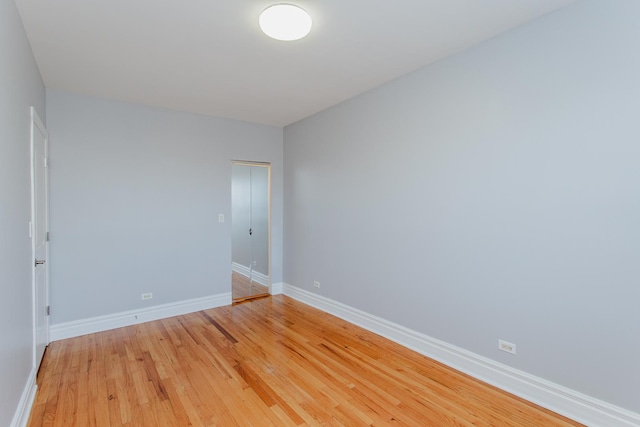 unfurnished room with baseboards and light wood-style flooring