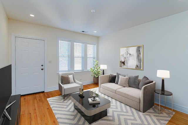 living room with visible vents, baseboards, wood finished floors, and recessed lighting