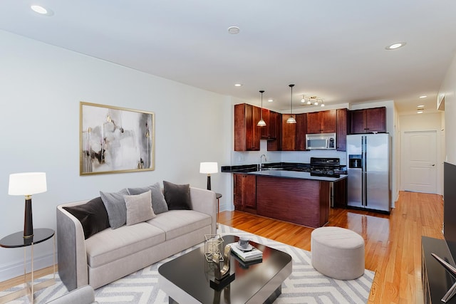living room with light wood-type flooring, baseboards, and recessed lighting