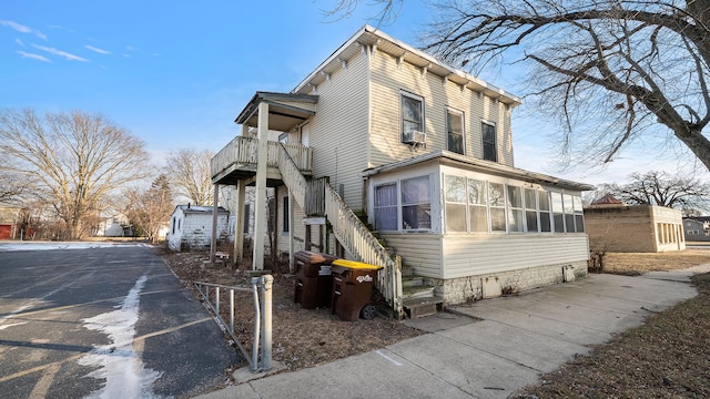 view of home's exterior featuring a sunroom and a balcony