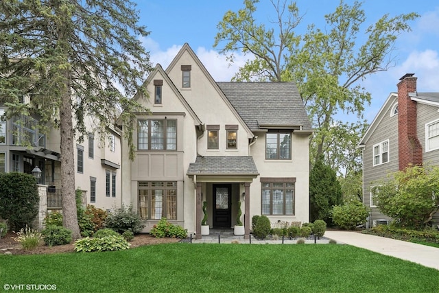 tudor-style house featuring a front yard