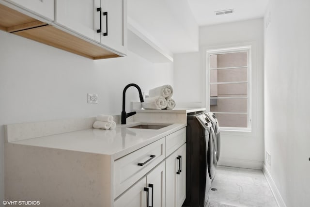 washroom featuring cabinets, separate washer and dryer, and sink