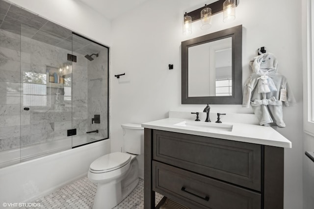 full bathroom featuring combined bath / shower with glass door, vanity, and toilet