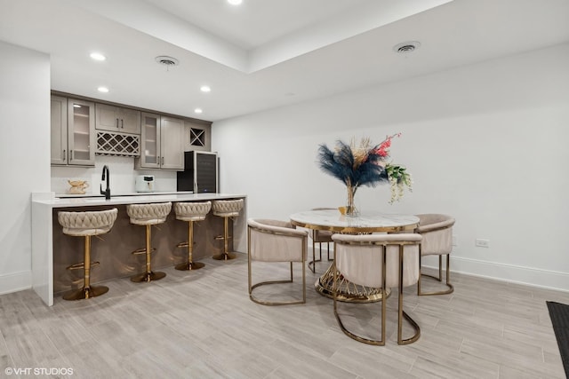 kitchen featuring light wood-type flooring, refrigerator, sink, and gray cabinets