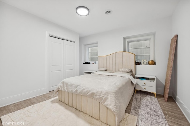 bedroom with a closet and light hardwood / wood-style floors