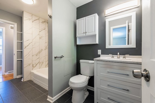 full bathroom featuring toilet, vanity, tiled shower / bath combo, and tile patterned flooring