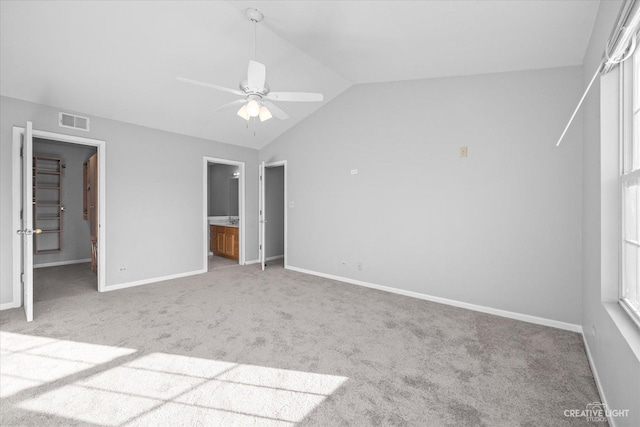 unfurnished bedroom featuring ensuite bath, vaulted ceiling, carpet, and ceiling fan