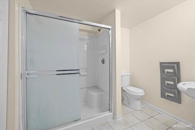 bathroom with toilet, tile patterned floors, and an enclosed shower