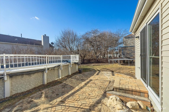 view of patio with a fenced in pool and a trampoline