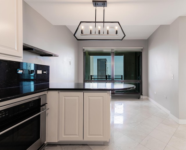 kitchen with white cabinets, decorative light fixtures, kitchen peninsula, a chandelier, and stainless steel oven