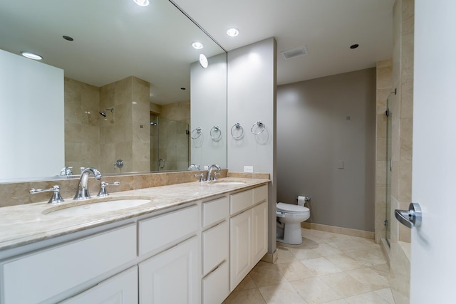 bathroom with toilet, a shower with door, and vanity