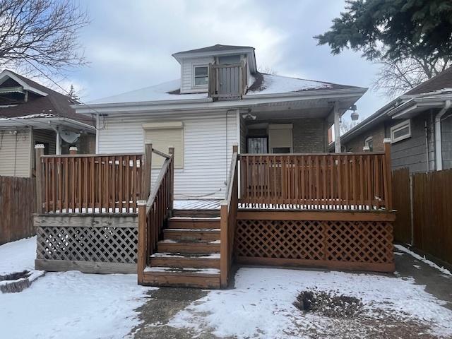 snow covered back of property featuring a deck