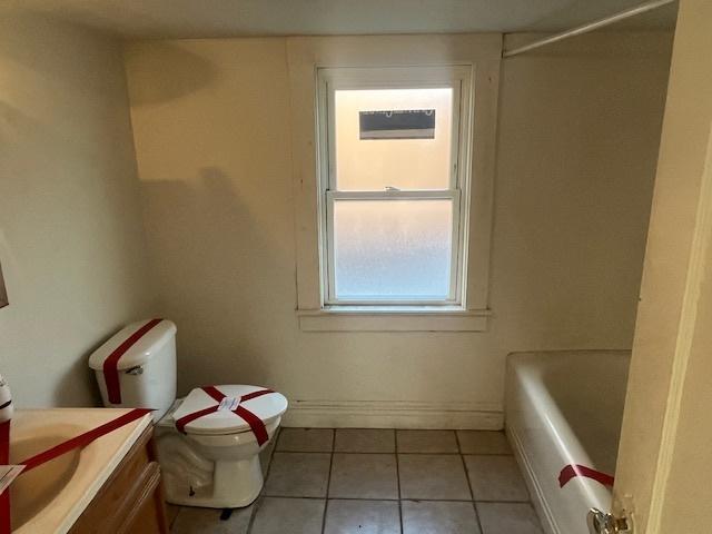 bathroom with toilet, vanity, a bath, and tile patterned flooring