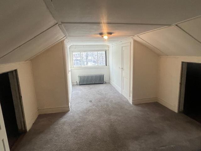 additional living space with carpet, radiator, and vaulted ceiling