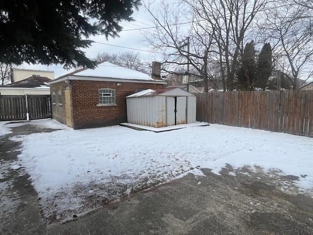 yard layered in snow featuring a shed