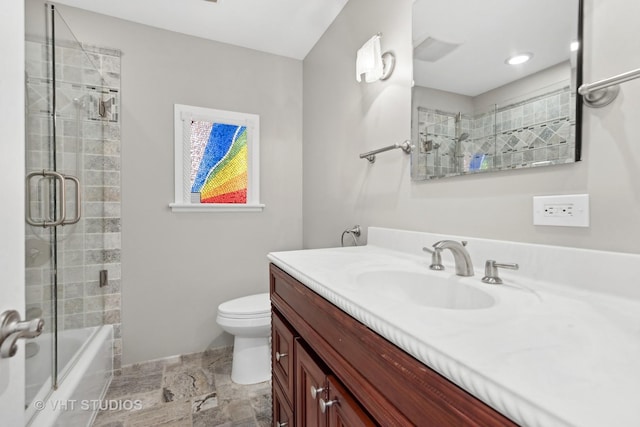 full bathroom with toilet, vanity, and bath / shower combo with glass door