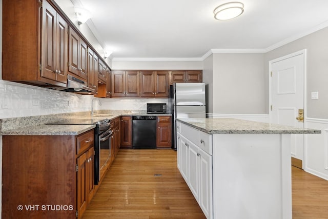 kitchen featuring black appliances, a kitchen island, tasteful backsplash, sink, and crown molding