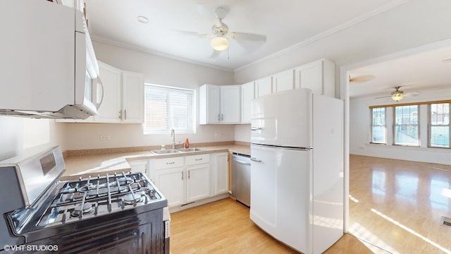 kitchen with appliances with stainless steel finishes, a healthy amount of sunlight, white cabinets, and sink