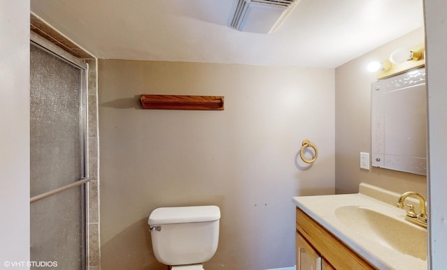 bathroom featuring a shower with shower door, toilet, and vanity