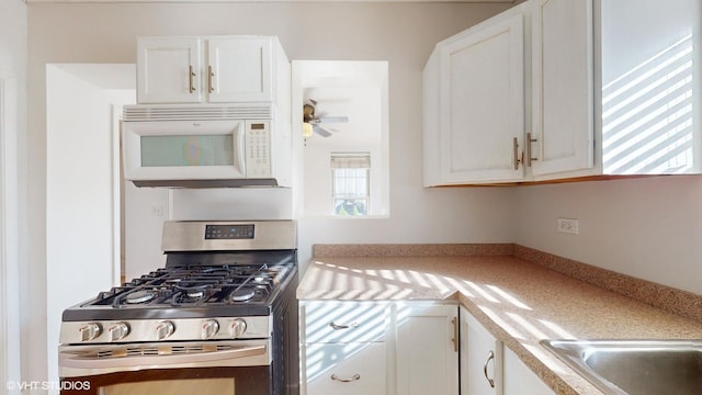 kitchen featuring ceiling fan, white cabinetry, and stainless steel gas range oven