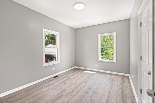 spare room featuring a healthy amount of sunlight and light hardwood / wood-style floors