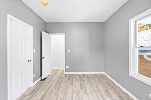 empty room with a healthy amount of sunlight and light hardwood / wood-style floors