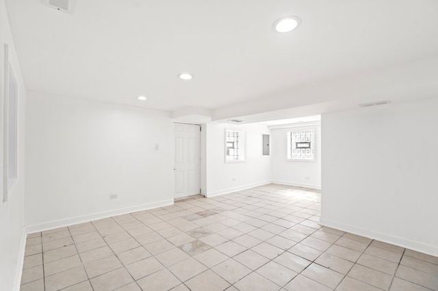 empty room featuring light tile patterned floors and electric panel