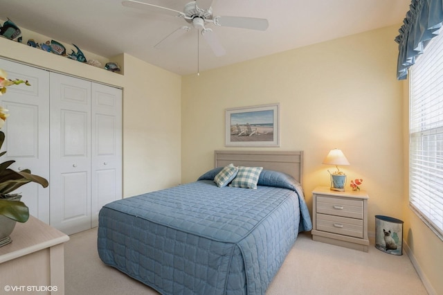 bedroom with ceiling fan, a closet, light carpet, and multiple windows