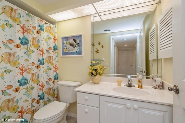 bathroom with toilet, vanity, and walk in shower