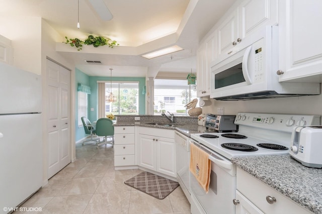 kitchen with sink, white cabinets, light stone counters, and white appliances