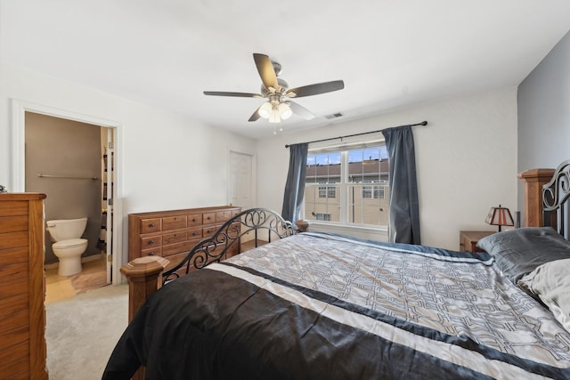 carpeted bedroom with ceiling fan and ensuite bath