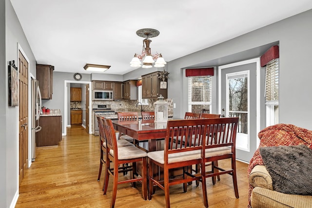 dining room with light hardwood / wood-style floors, plenty of natural light, and a chandelier