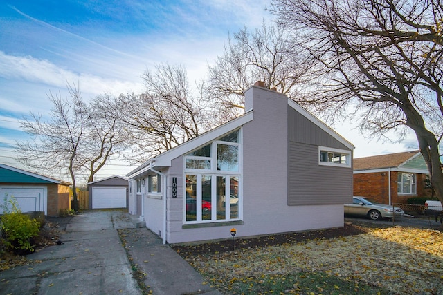 view of side of home featuring an outbuilding and a garage