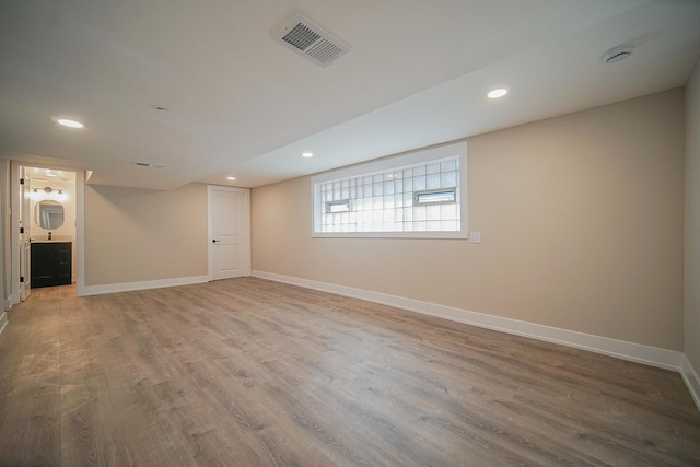 basement with hardwood / wood-style flooring