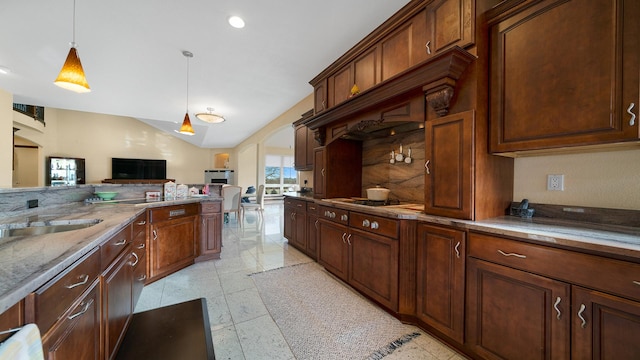 kitchen with vaulted ceiling, decorative light fixtures, backsplash, black gas stovetop, and light stone countertops