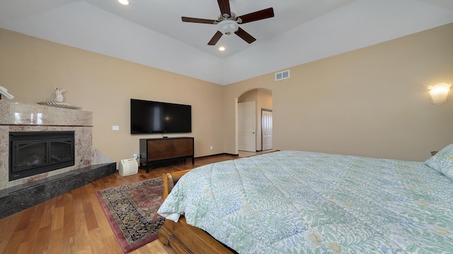 bedroom featuring hardwood / wood-style flooring and a premium fireplace