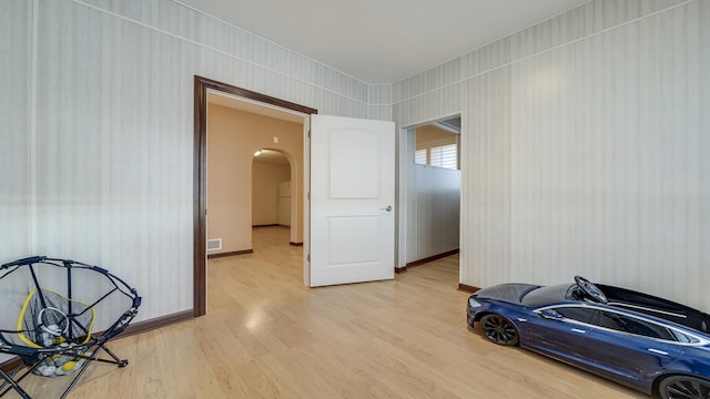 14481 Berglund Rd, Pecatonica, IL 61063 - unfurnished room with arched walkways, light wood-type flooring, and baseboards