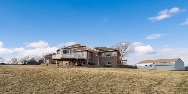 rear view of property featuring an outbuilding, a yard, a deck, and a garage