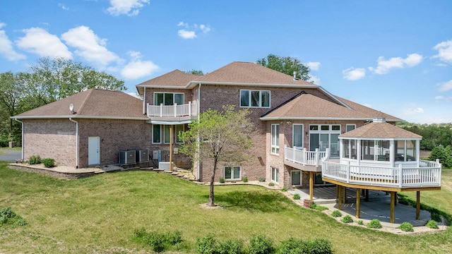 14481 Berglund Rd, Pecatonica, IL 61063 - back of house featuring a patio, cooling unit, a balcony, brick siding, and a lawn