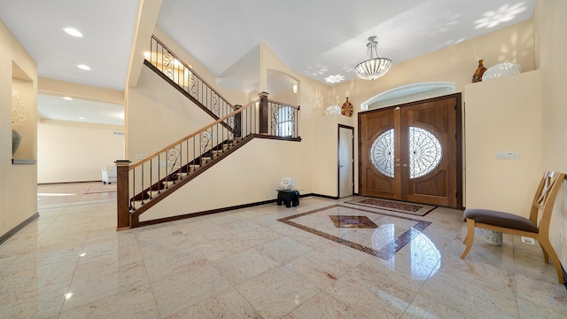 foyer entrance featuring a towering ceiling and a notable chandelier