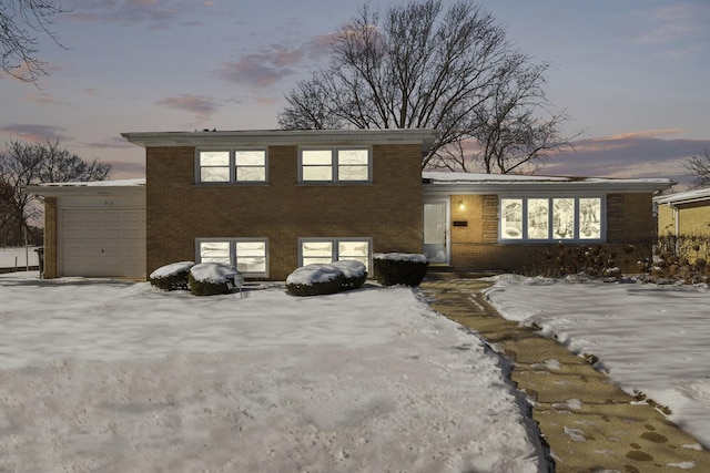 tri-level home featuring brick siding and a garage