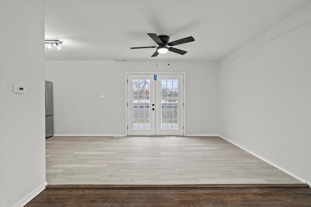 unfurnished room featuring ceiling fan, french doors, and light wood-type flooring