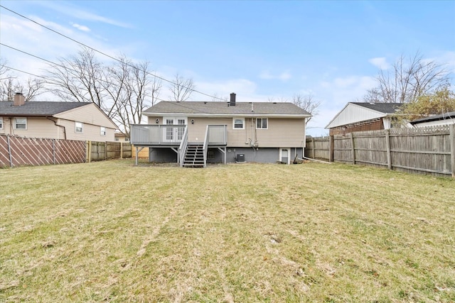 rear view of property with a deck and a yard