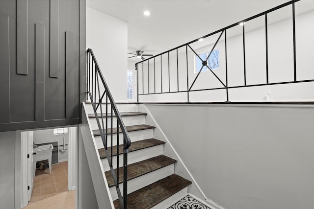 stairs featuring ceiling fan and tile patterned floors