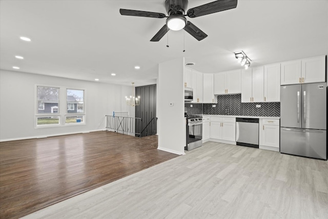 kitchen with ceiling fan, hanging light fixtures, light wood-type flooring, appliances with stainless steel finishes, and white cabinets