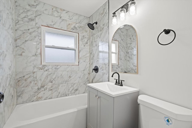 full bathroom featuring toilet, tiled shower / bath combo, and vanity