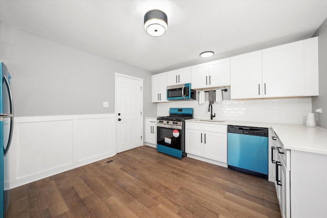 kitchen with white cabinetry, sink, dark hardwood / wood-style floors, and appliances with stainless steel finishes