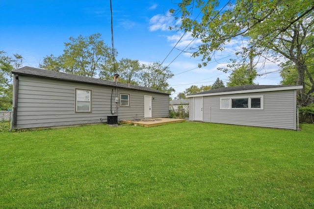 rear view of house featuring central AC and a yard